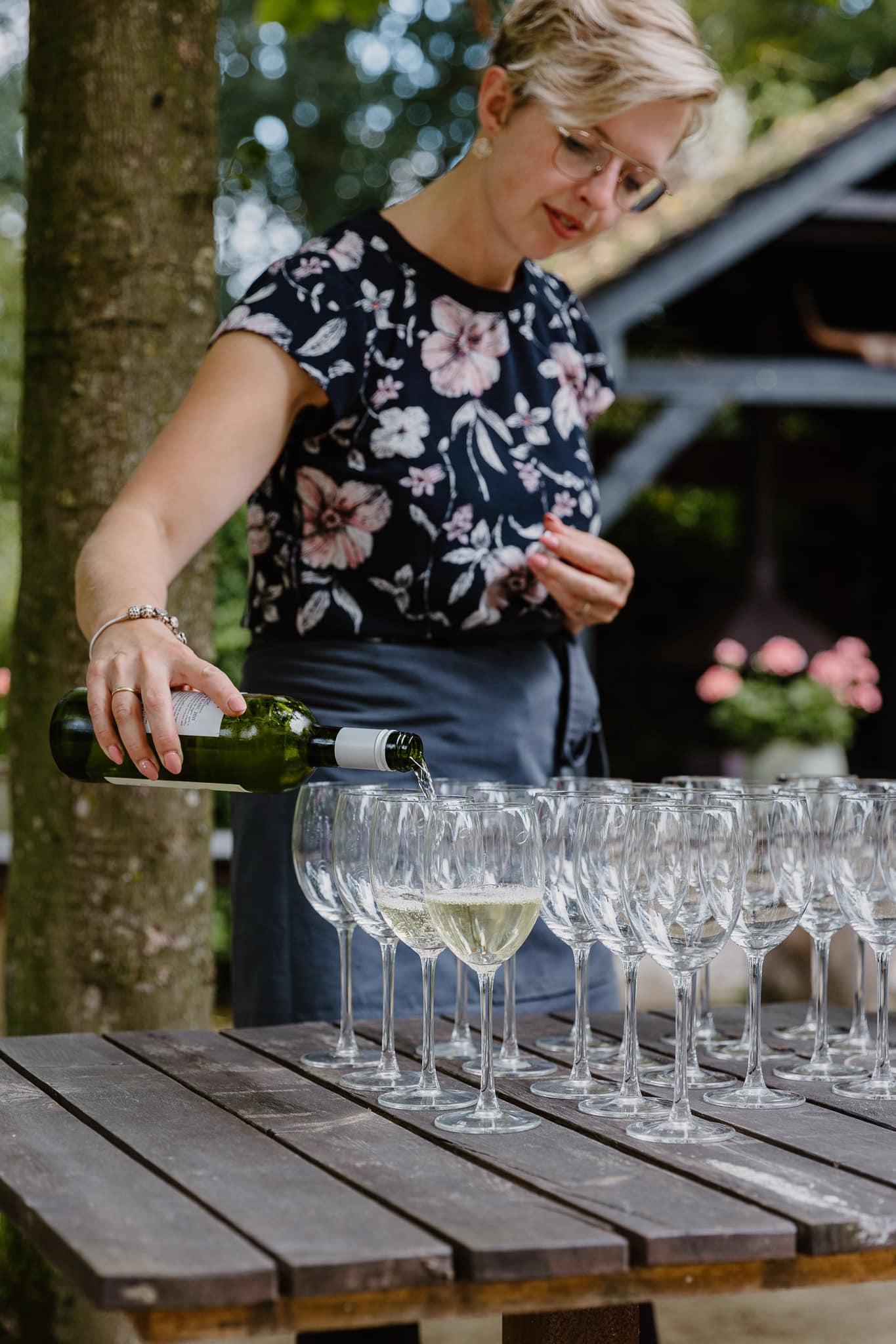 Prosecco wordt buiten ingeschonken door een vrouwlijke ober tijdens de trouwreceptie bij de Jufferen Lunsingh.