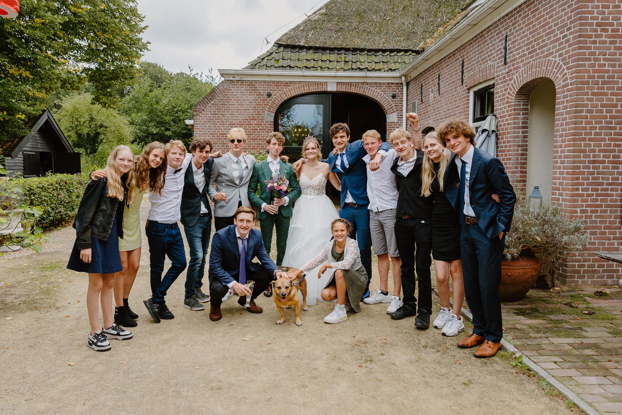 Groepsfoto van bruiloftsgasten met het bruidspaar bij de Jufferen Lunsingh in Westervelde.