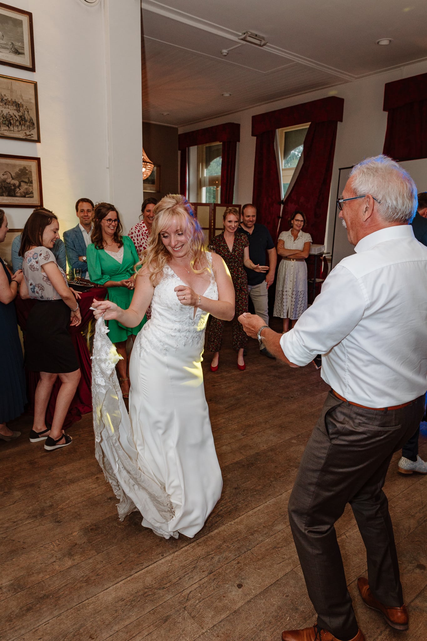 Bruid danst met haar nieuwe schoonvader tijdens het trouwfeest in Groningen.