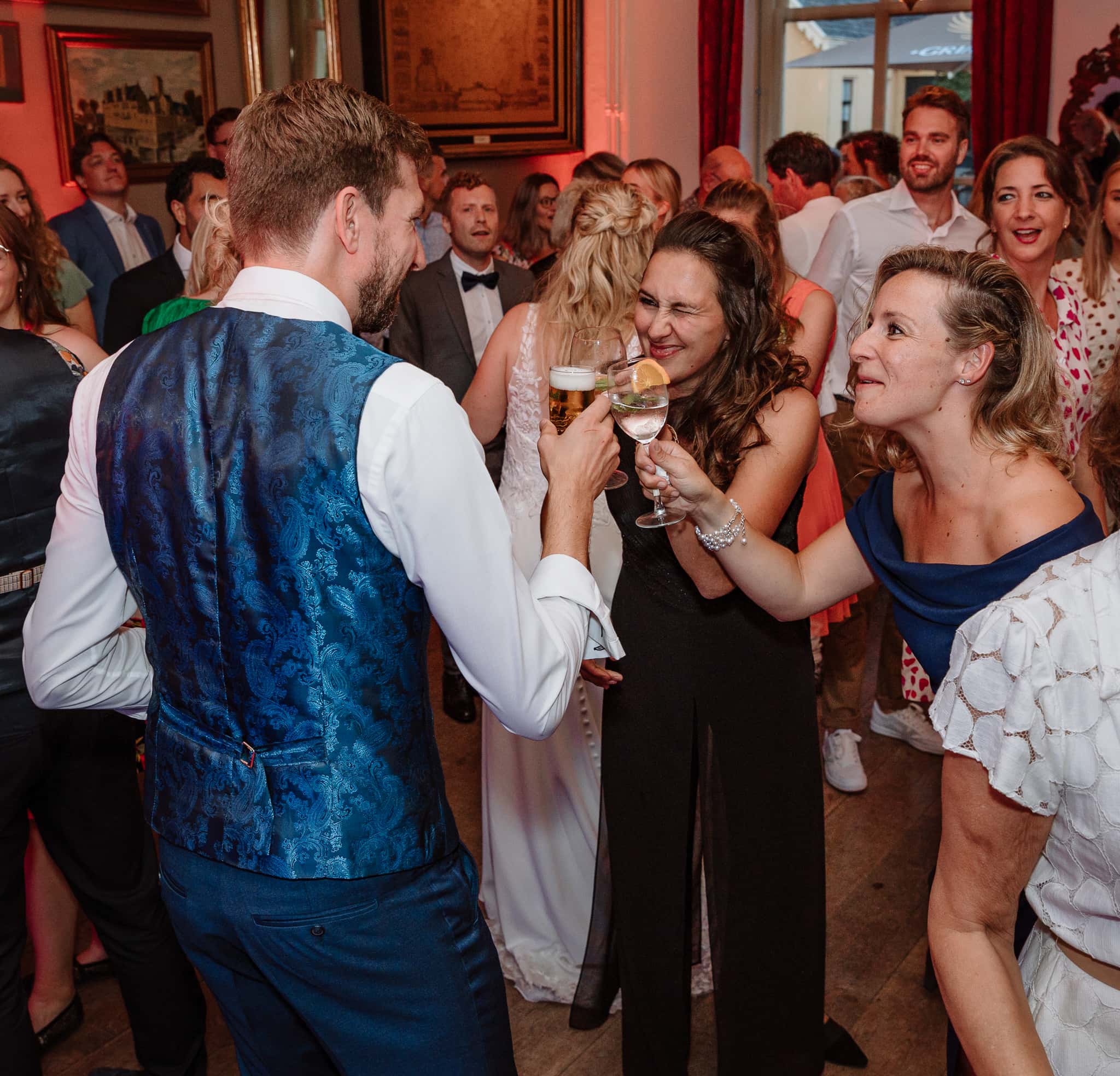 Bruidegom proost met zijn nieuwe schoonzussen tijdens het trouwfeest.