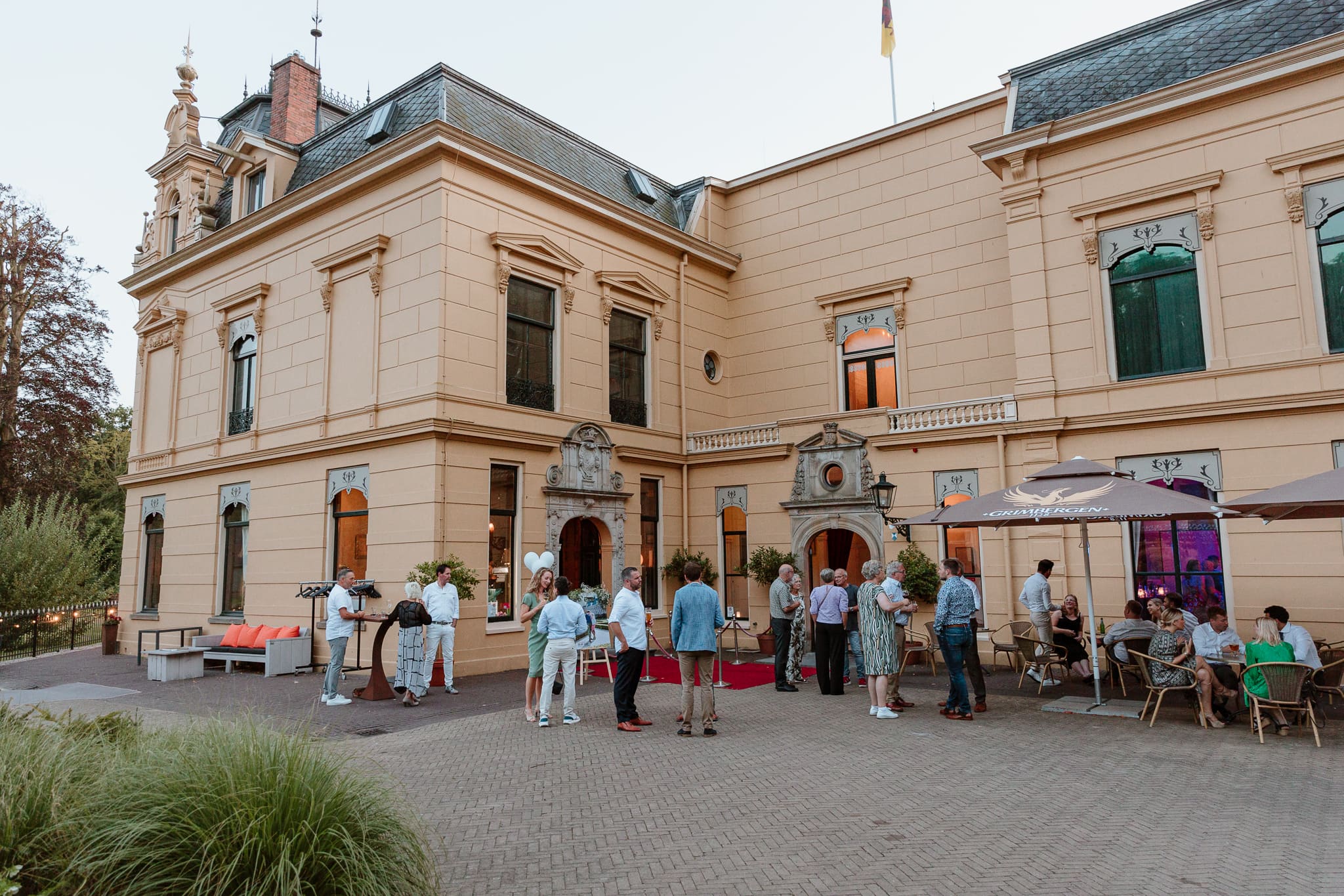 Bruiloftsgasten staan te borrelen voor Borg Nienoord in Leek.