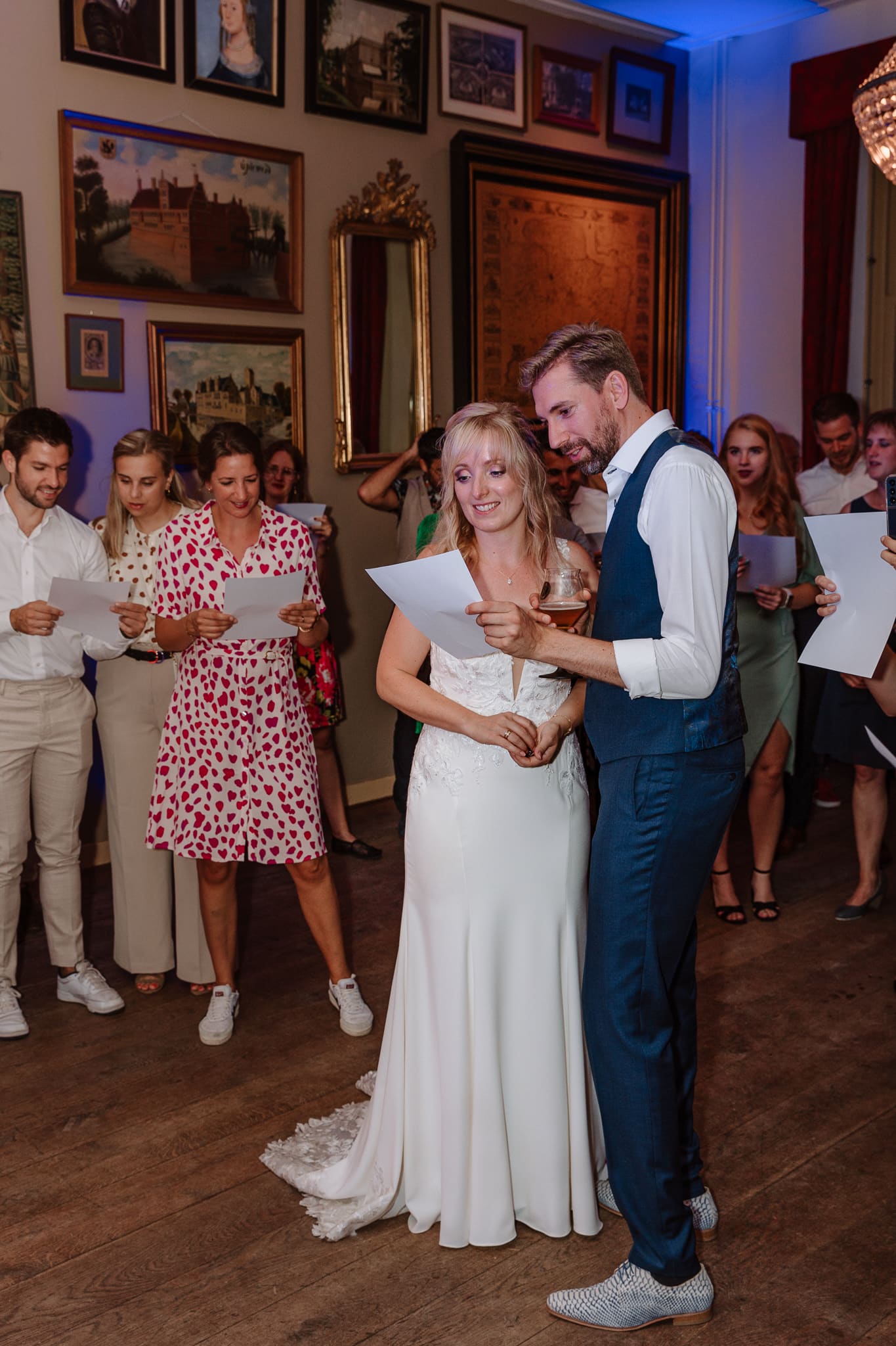 Trouwfotograaf Groningen legt een bruidspaar dat de tekst leest van een liedje over hen geschreven door vrienden.