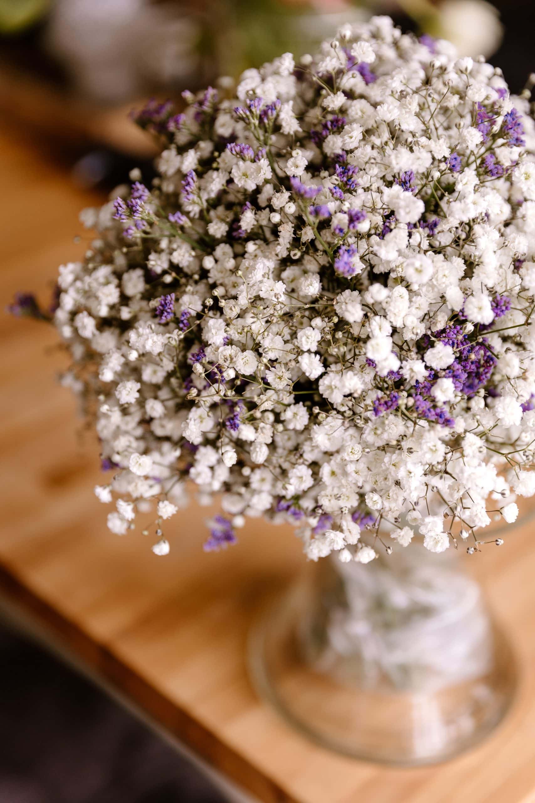 Bruidsboeket van wit gipskruid en paarse bloemen.