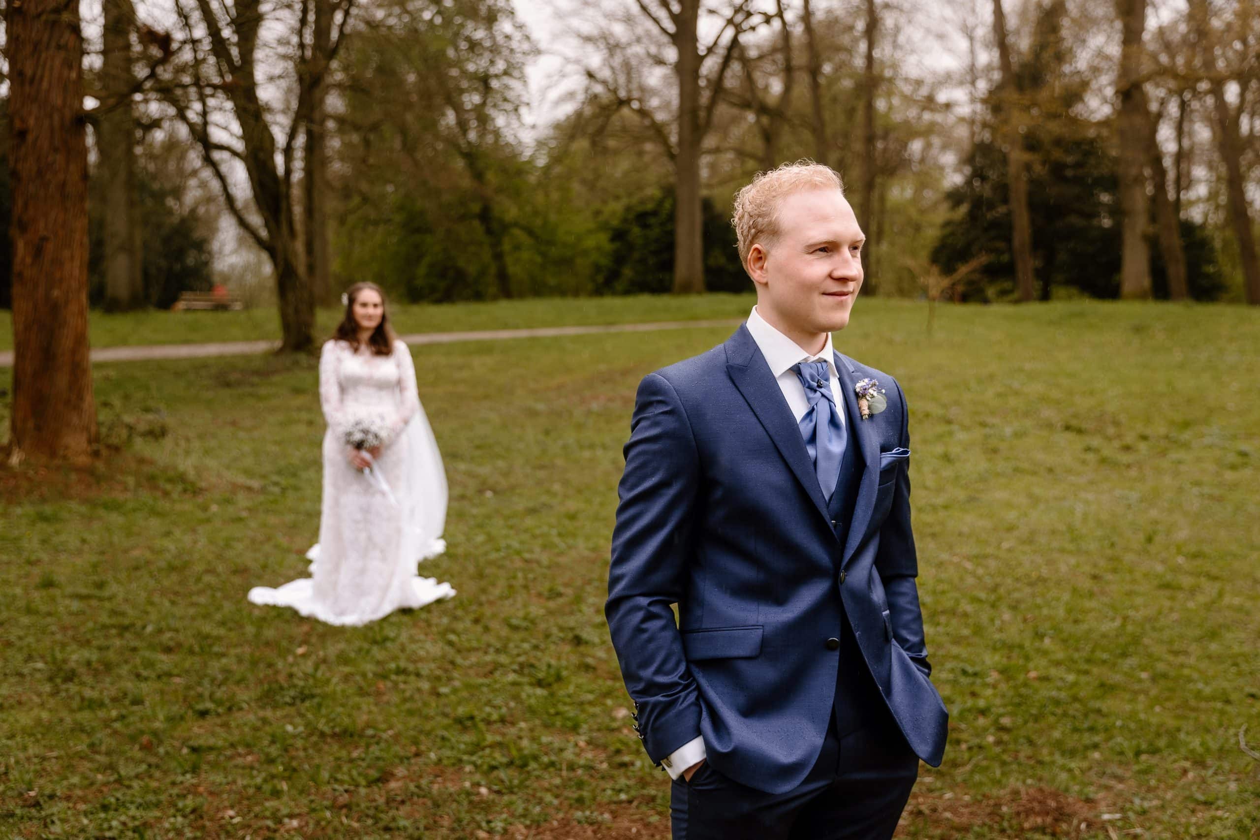 Een bruidspaar staat in park het Engelse Werk klaar voor de first look en de trouwfoto's.