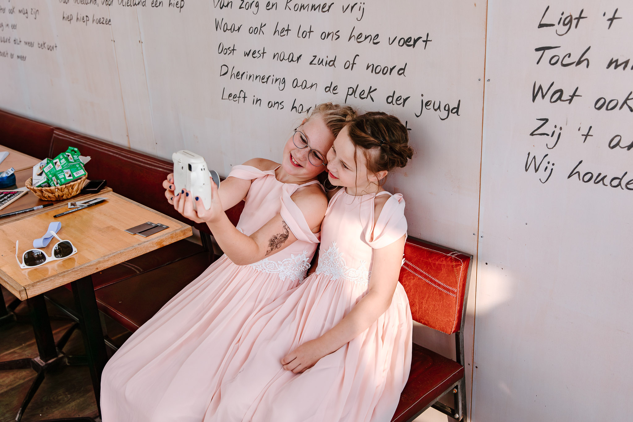 Twee bruidsmeisjes maken een selfie tijdens een strandbruiloft op Vlieland.