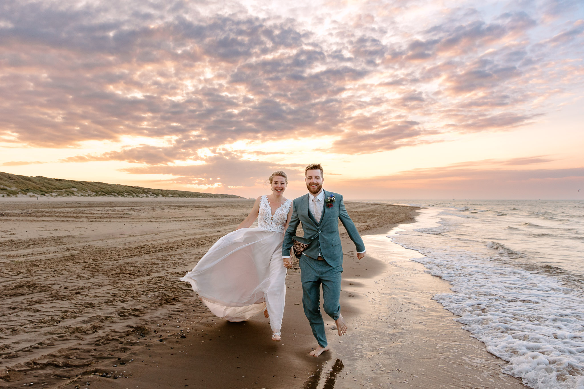 Een stel trouwt op het strand bij zonsondergang op Vlieland.