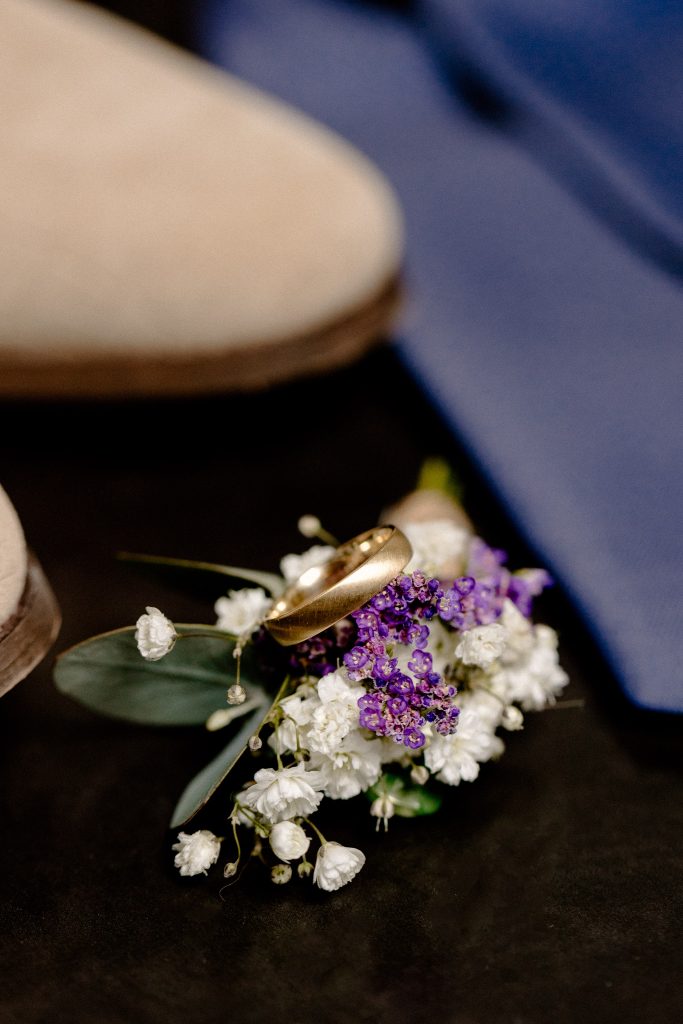 Een paar schoenen naast een corsage in de prachtige Schepenzaal in Zwolle.