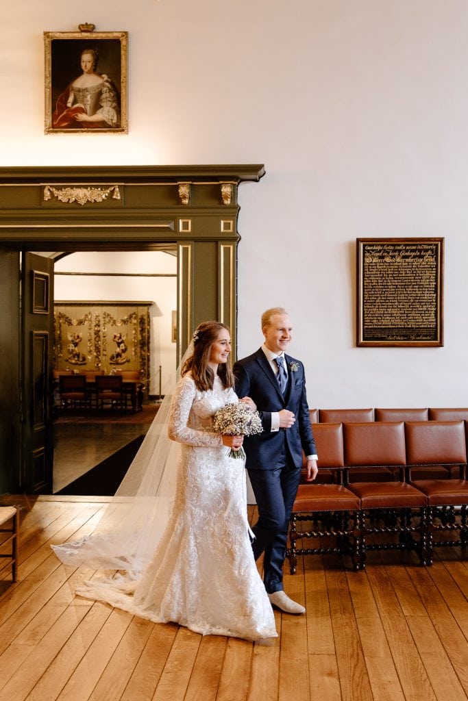 Een bruid en bruidegom lopen samen naar hun trouwceremonie in Zwolle.