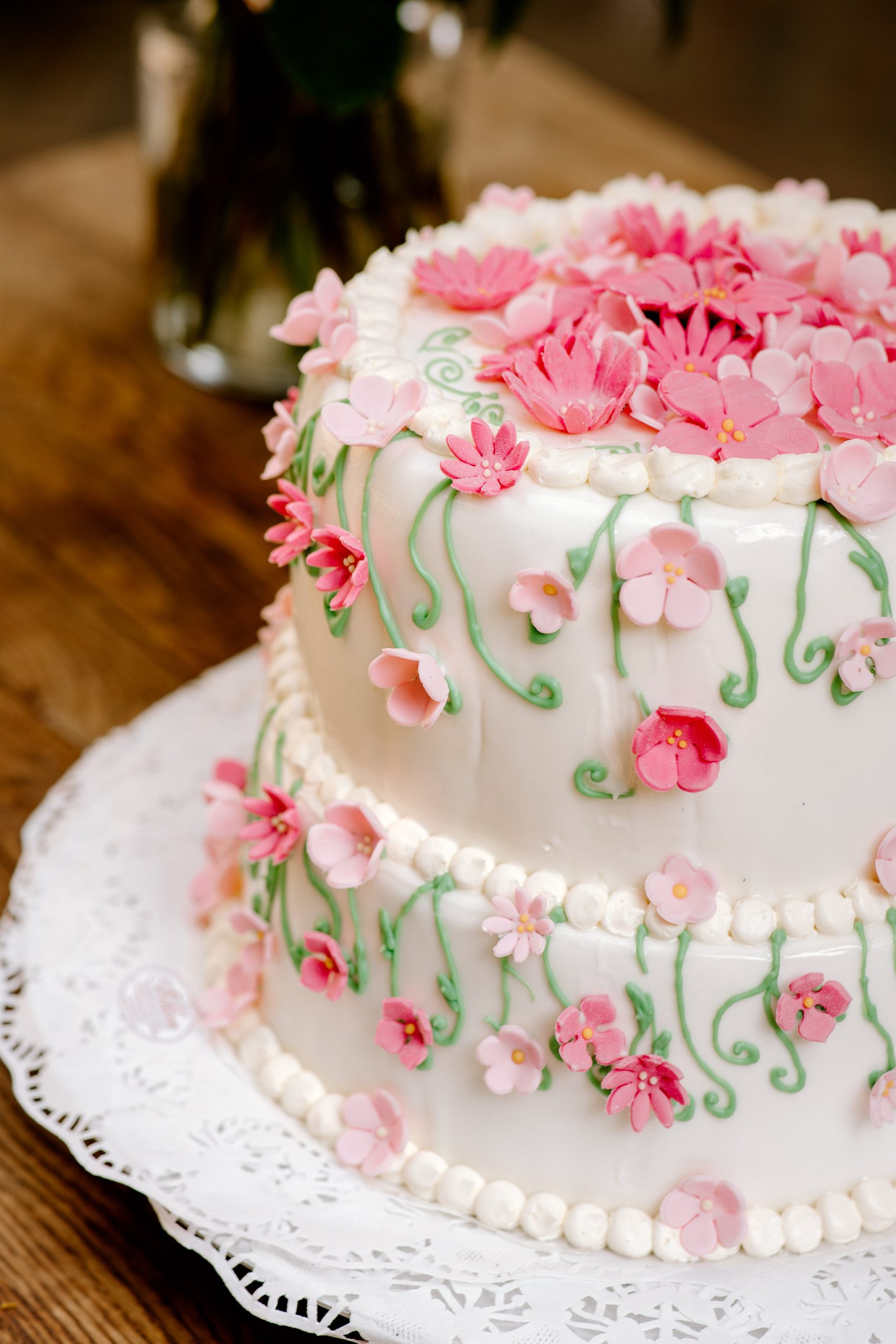 Een close-up van de bruidstaart gedecoreerd met roze bloemetjes, gemaakt door een trouwfotograaf uit Friesland.