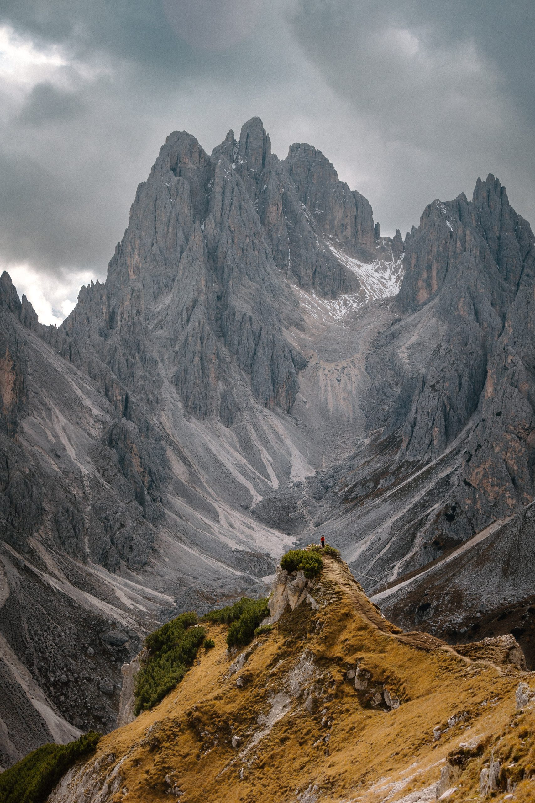 Een fotograaf staande op de top van een berg in de Dolomieten.